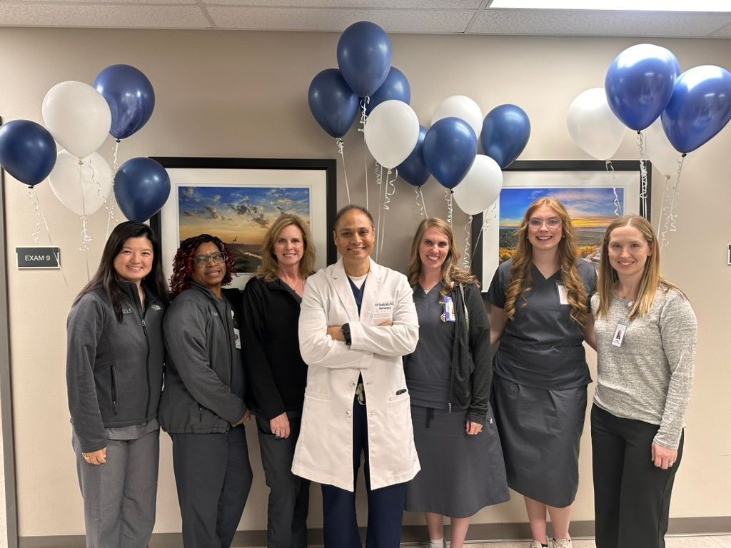 The Pinnacle Spine & Neurosurgery team (Dr. Gandhi and his team) pose indoors under blue and white balloons.