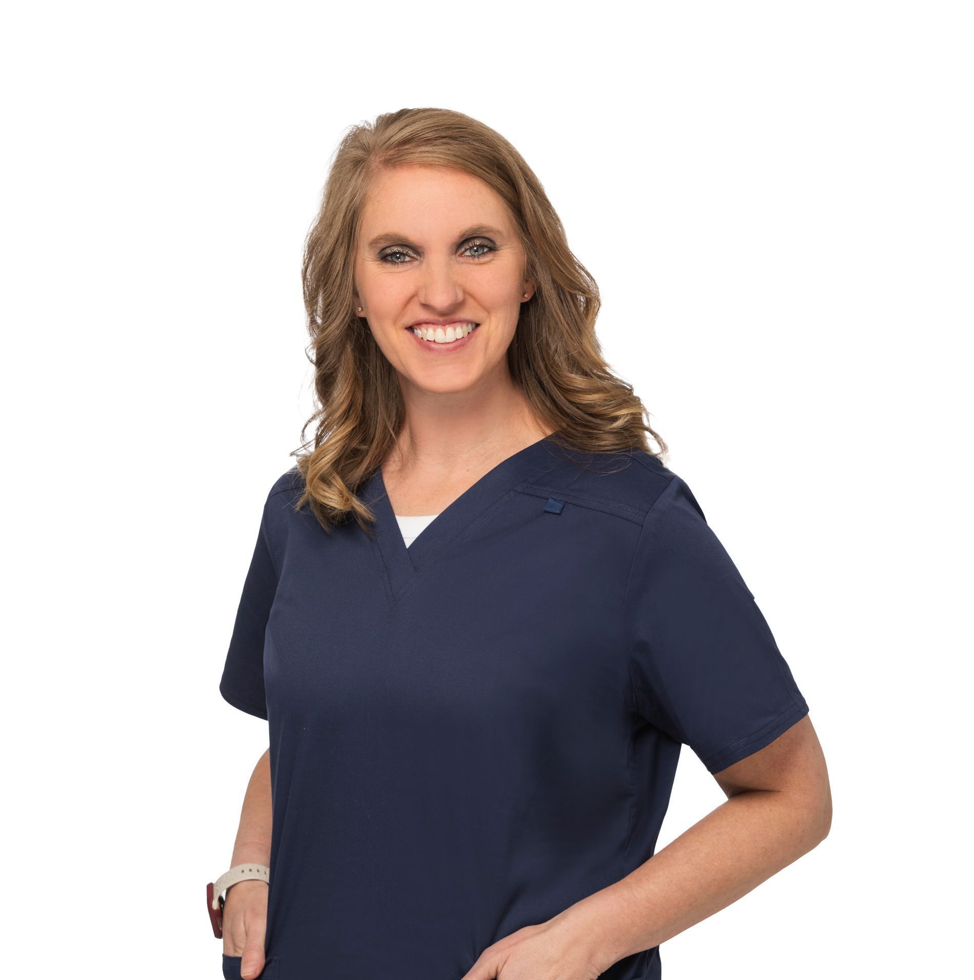 Smiling person in navy scrubs posing against a white background