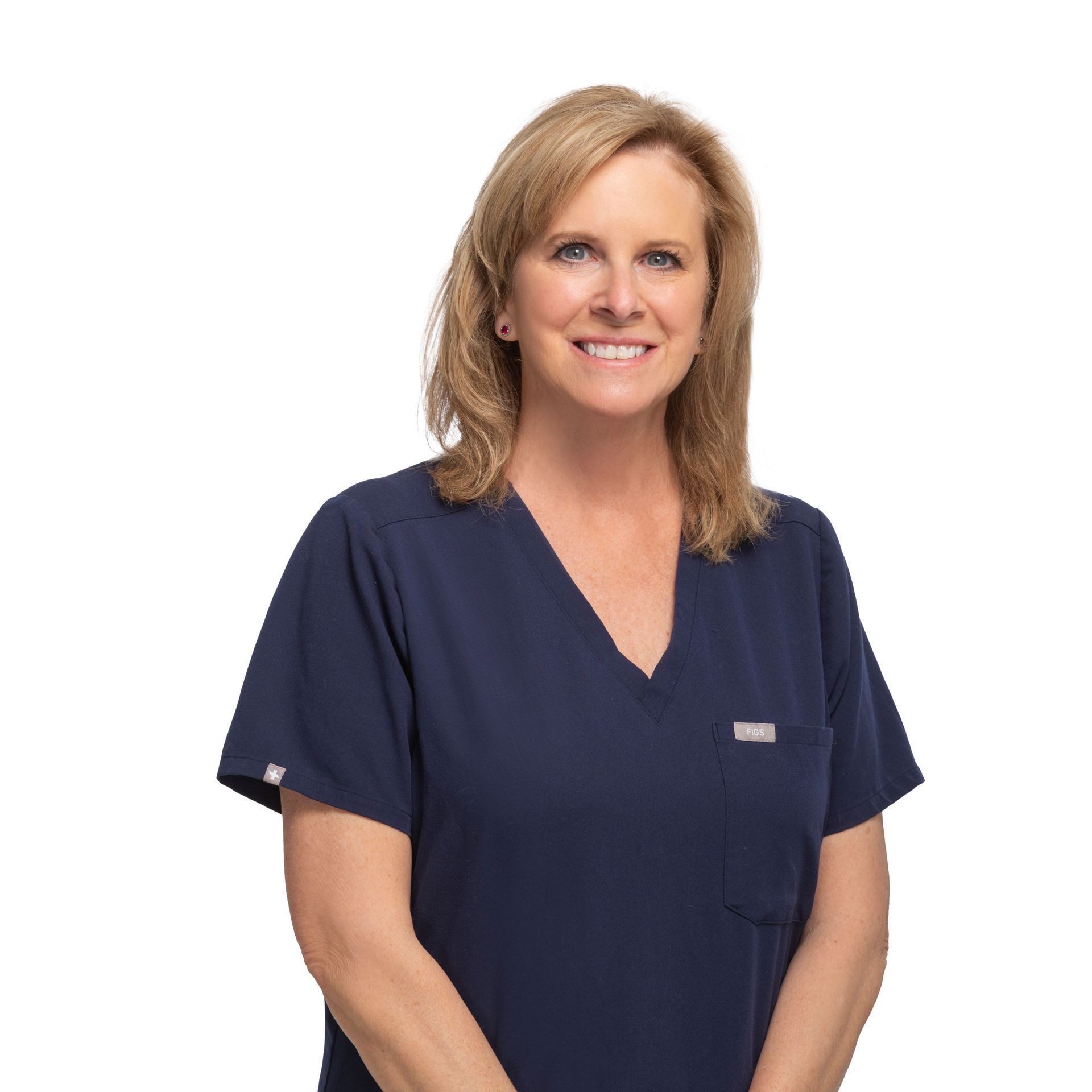 Woman in navy scrubs smiling against a white background