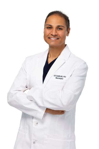 Smiling medical professional in a white lab coat with arms crossed against a white background