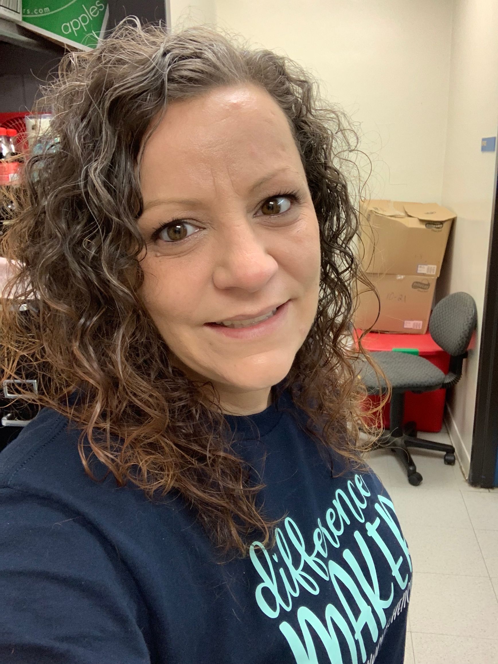 Woman with curly hair smiling at the camera.