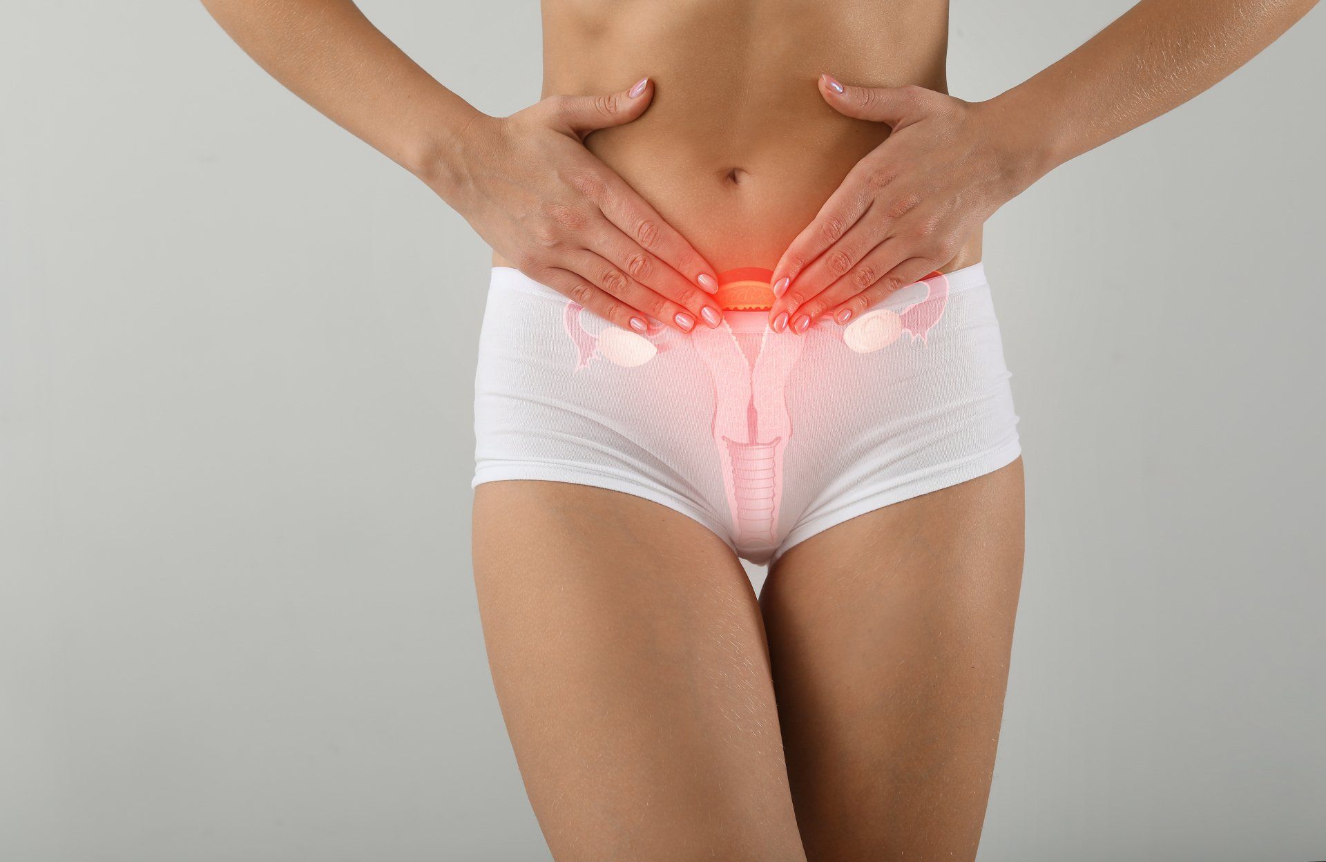Woman in white underwear, hands on abdomen, with highlighted internal female reproductive organs, indicating pain.