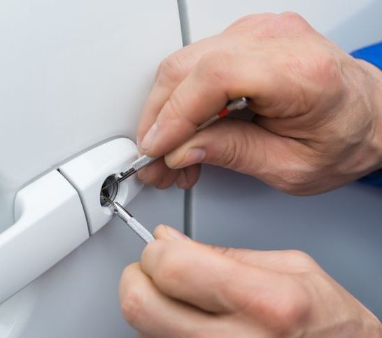 Hand Holding Lockpicker To Open Car Door