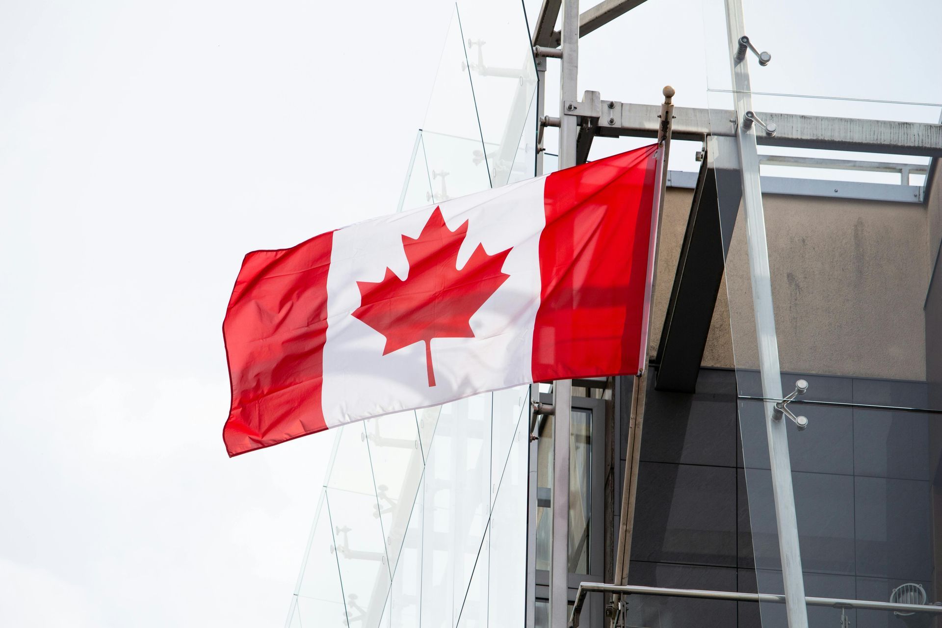 Canadian flag waving beside a modern building