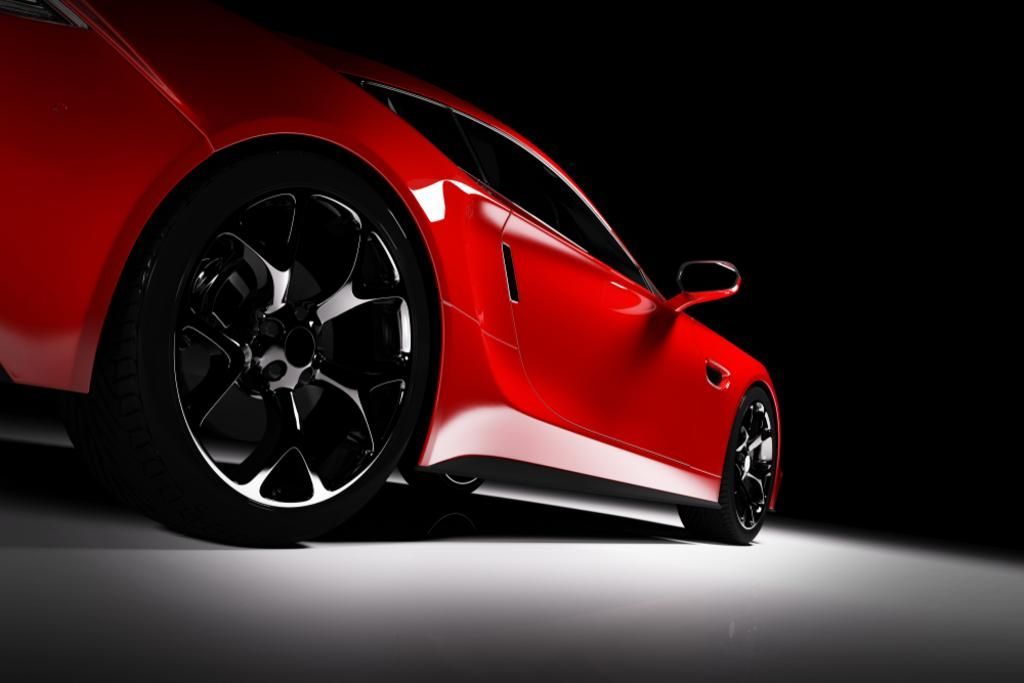 A red sports car is parked on a white surface