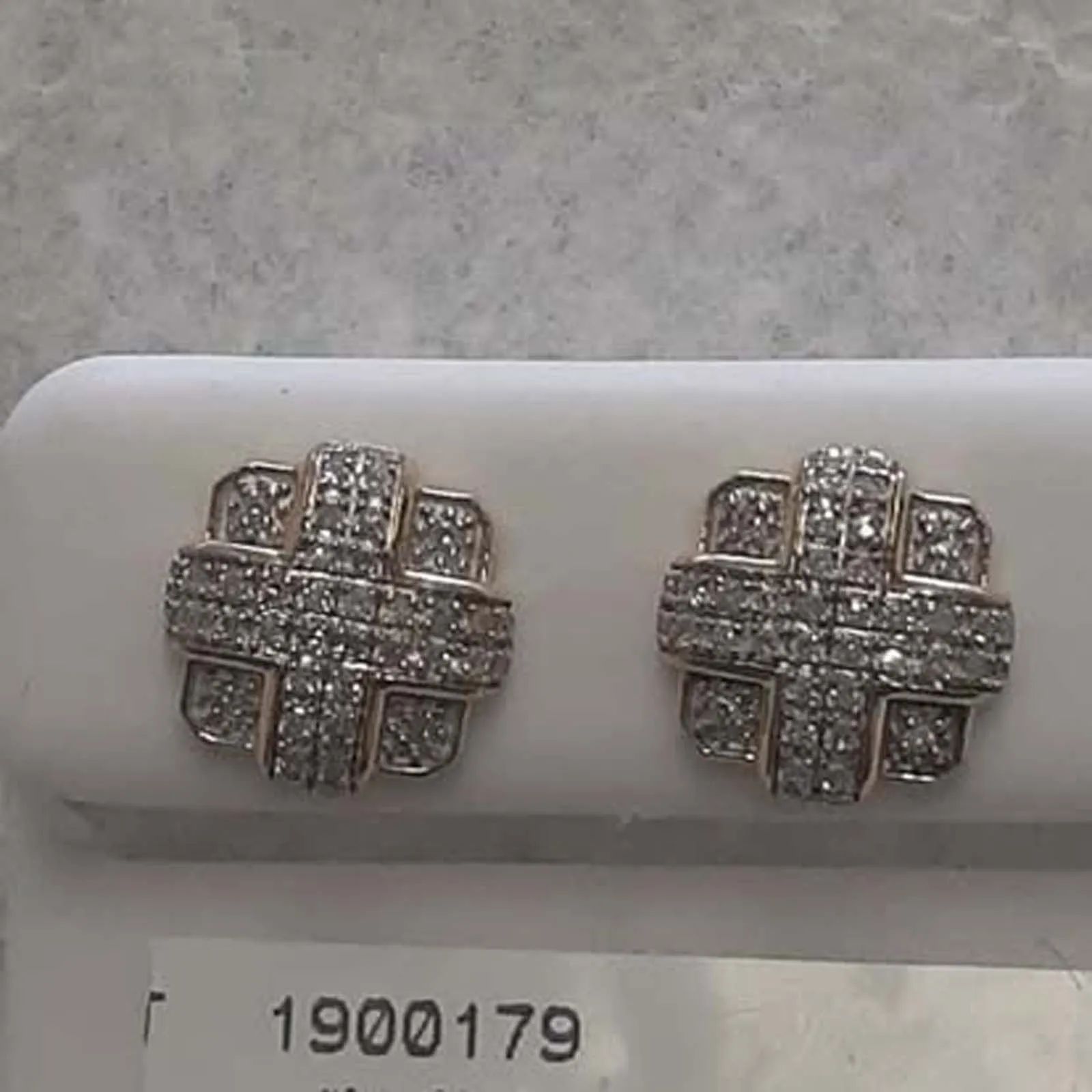 A pair of diamond stud earrings in a white box