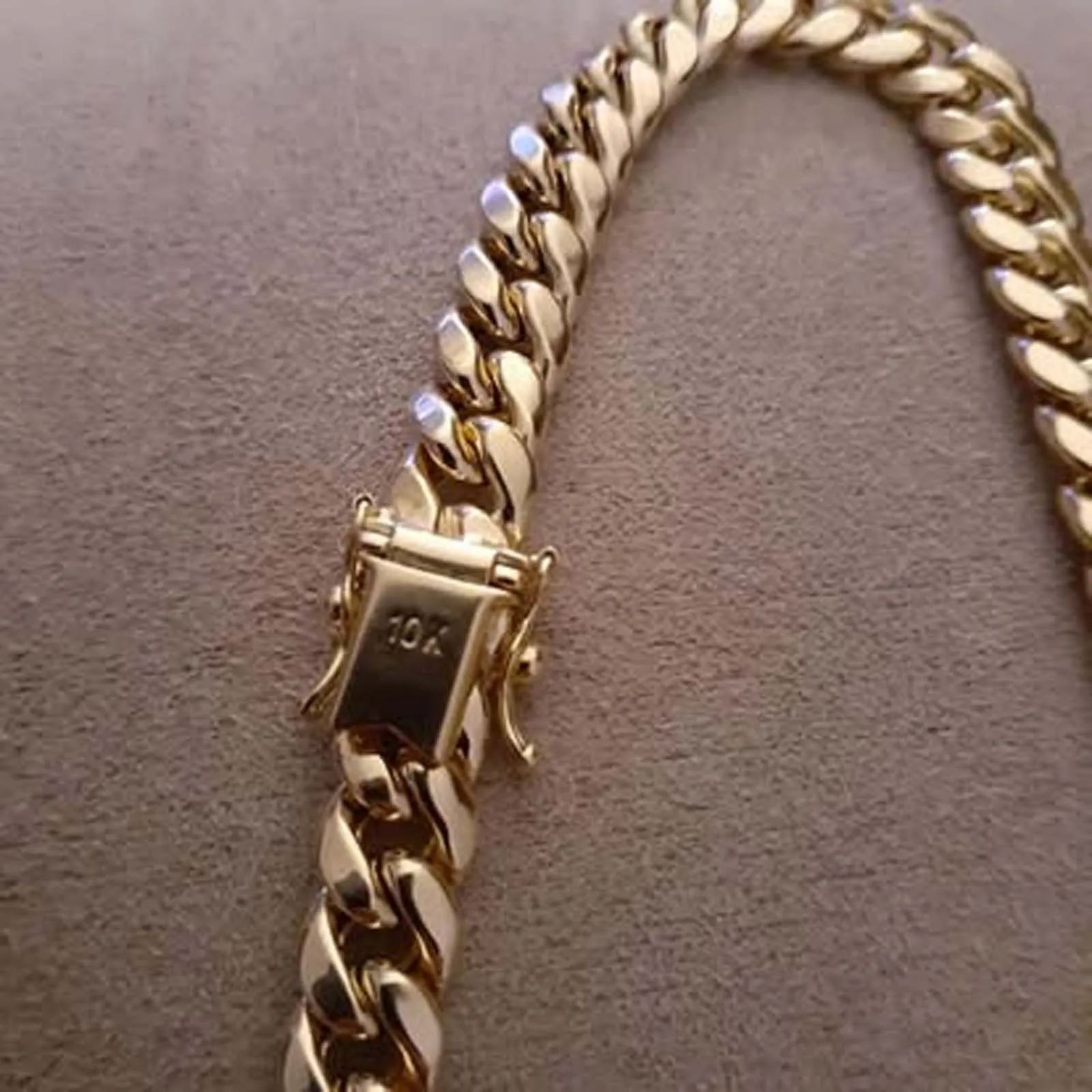 A close up of a gold chain on a table.