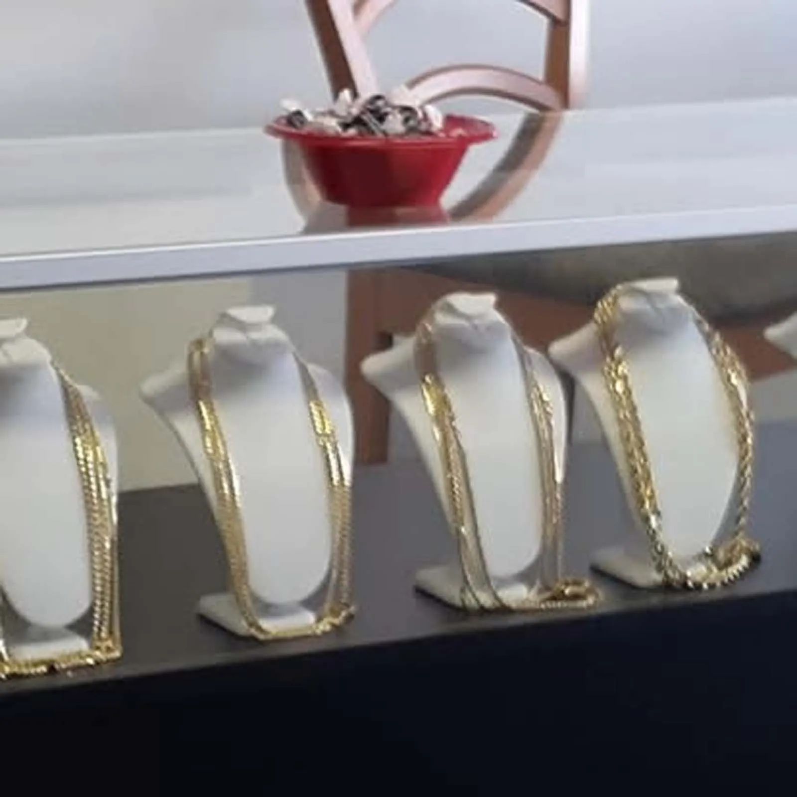 A display of gold necklaces on mannequins in a store