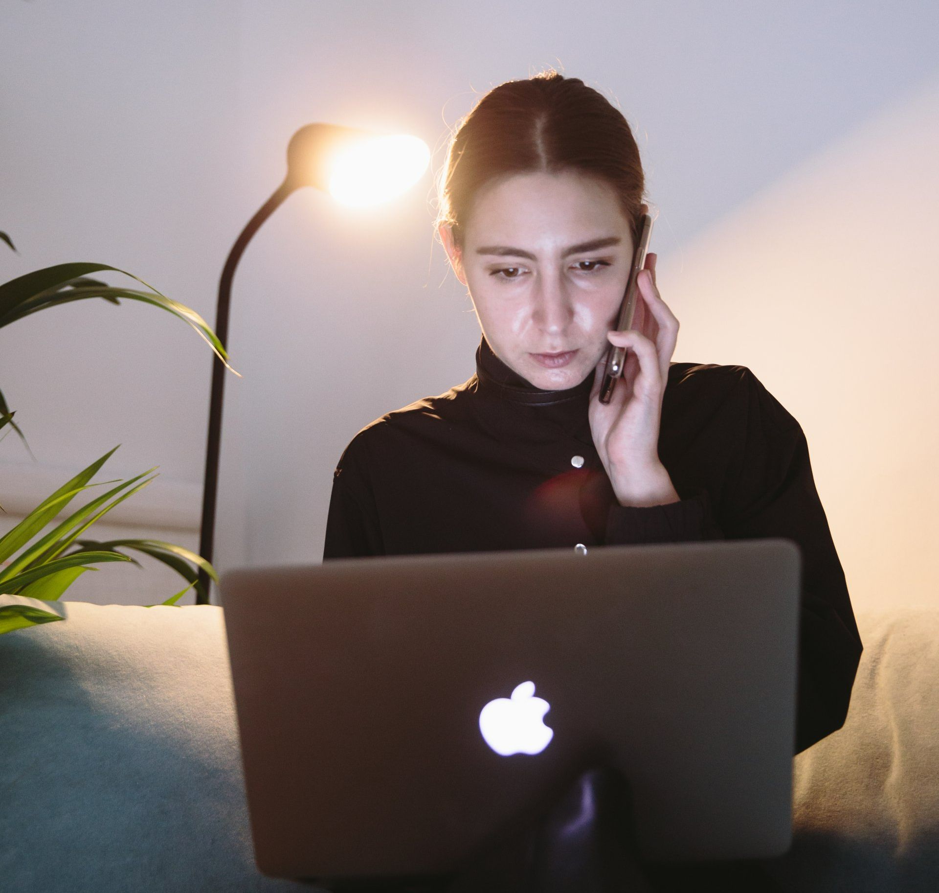 Person speaking on the phone while working on a mac computer
