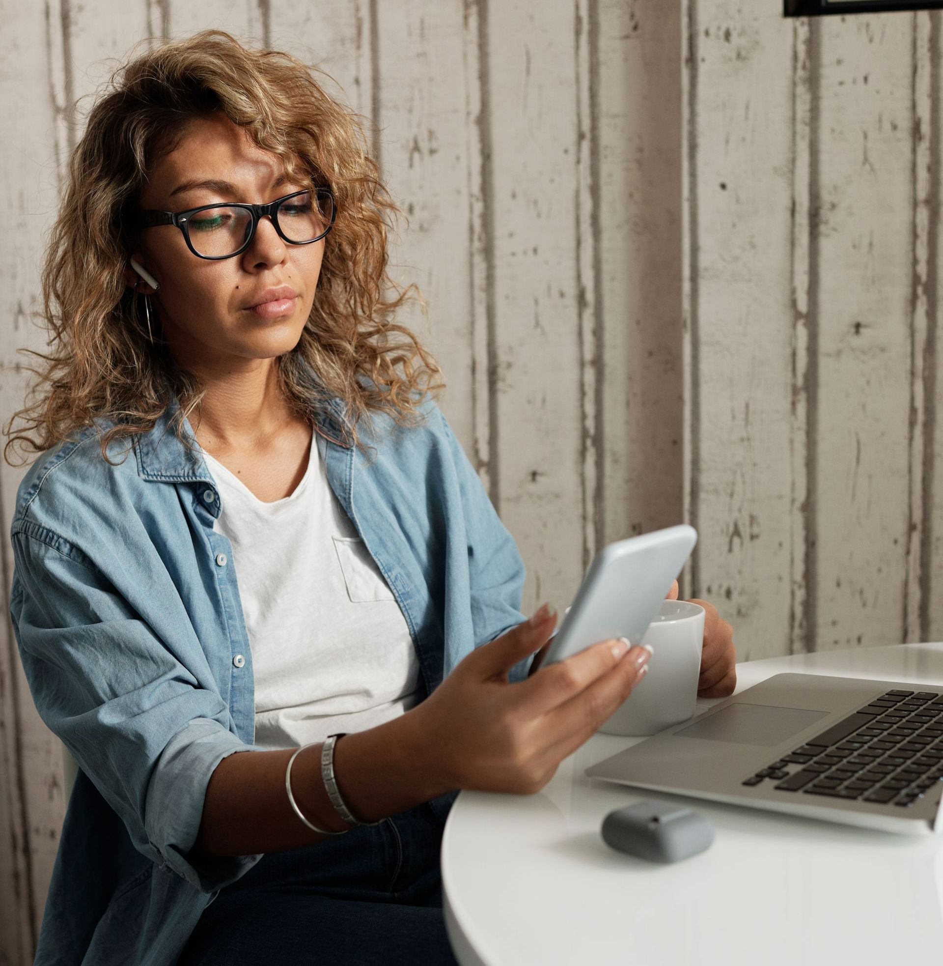 Mom working on a computer distracted by her phone