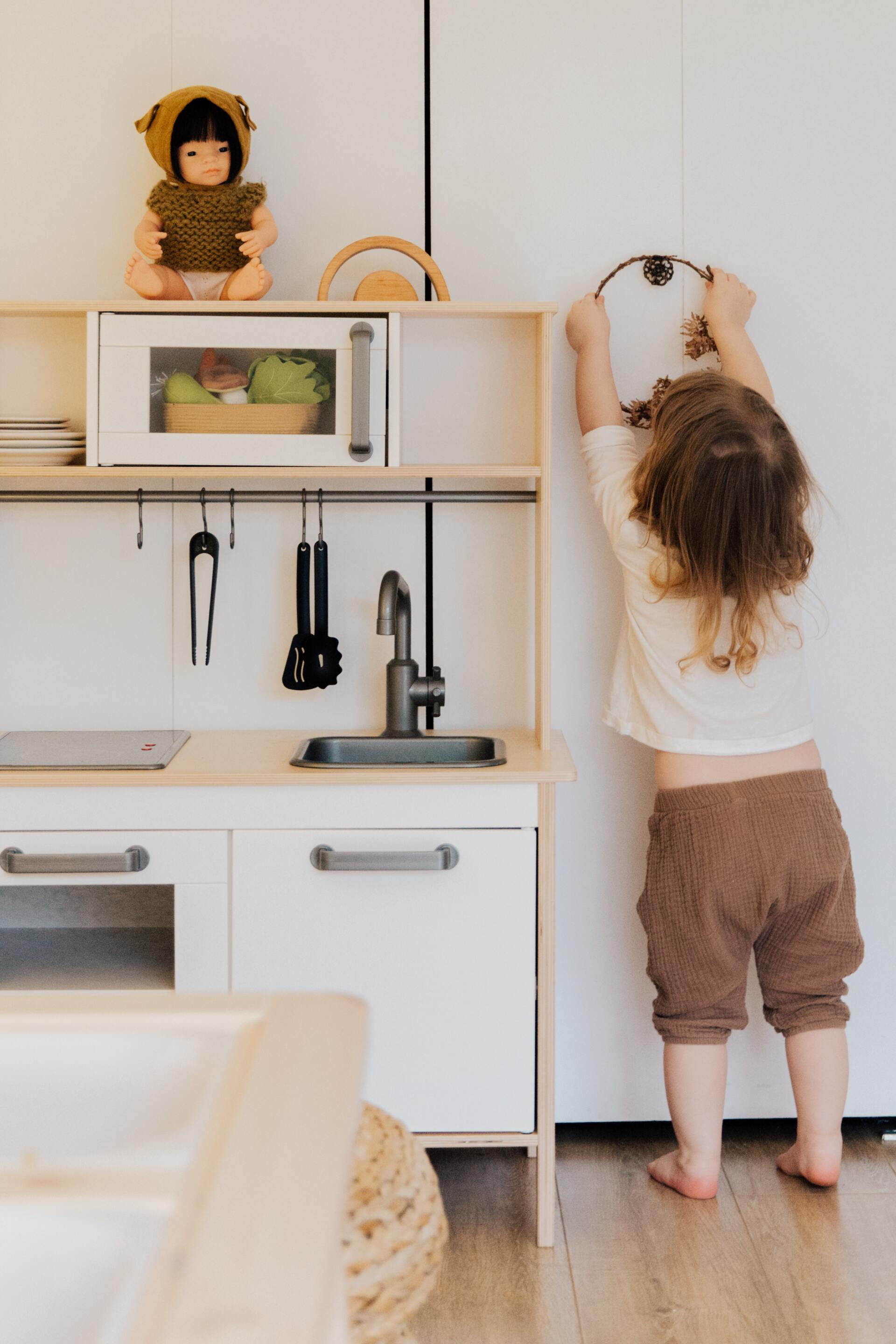 young kid organizing and tidying things up on her playroom