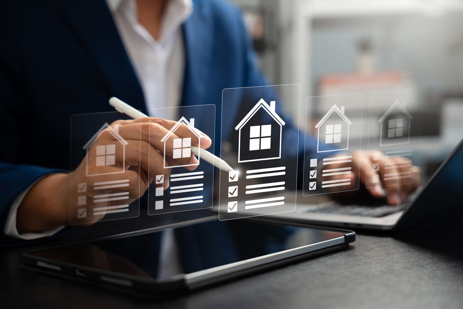 Business person using a tablet with holographic house icons for digital real estate search