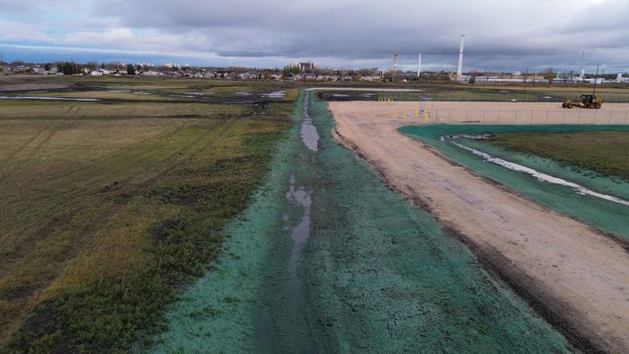 A ditch and field with  hydroseed running through it, erosion control