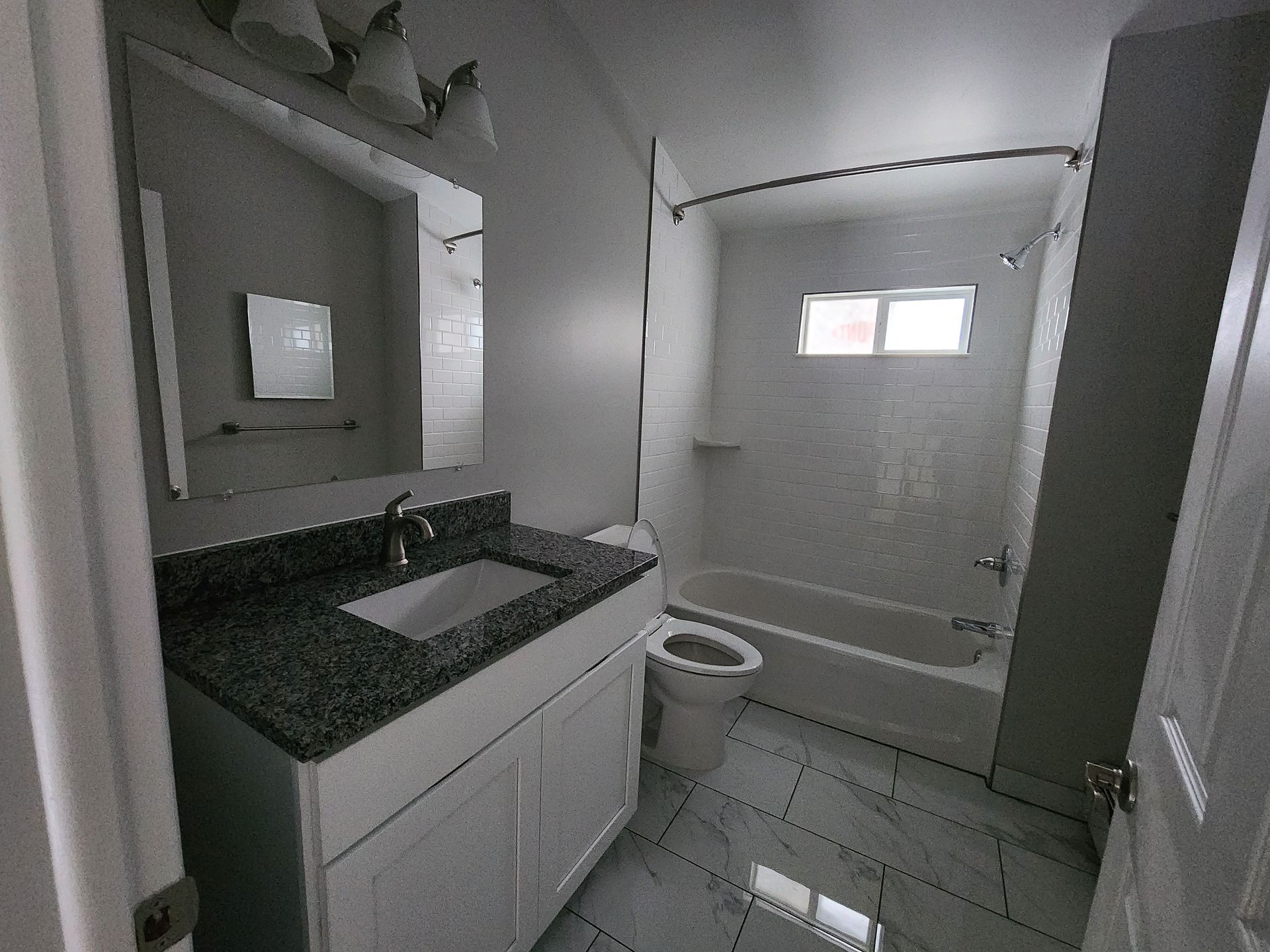 A bathroom with a sink , toilet , tub and mirror