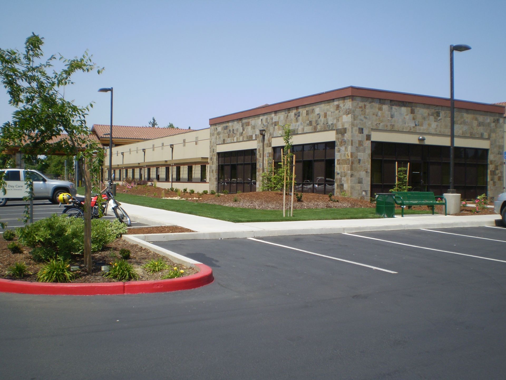 a large building with a lot of windows is next to a parking lot