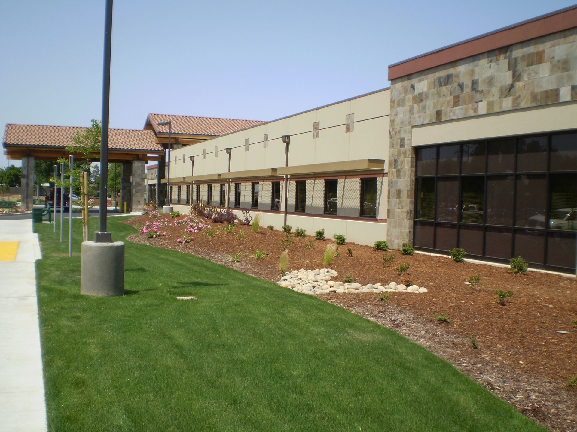 a large building with a lot of windows and a lush green lawn in front of it