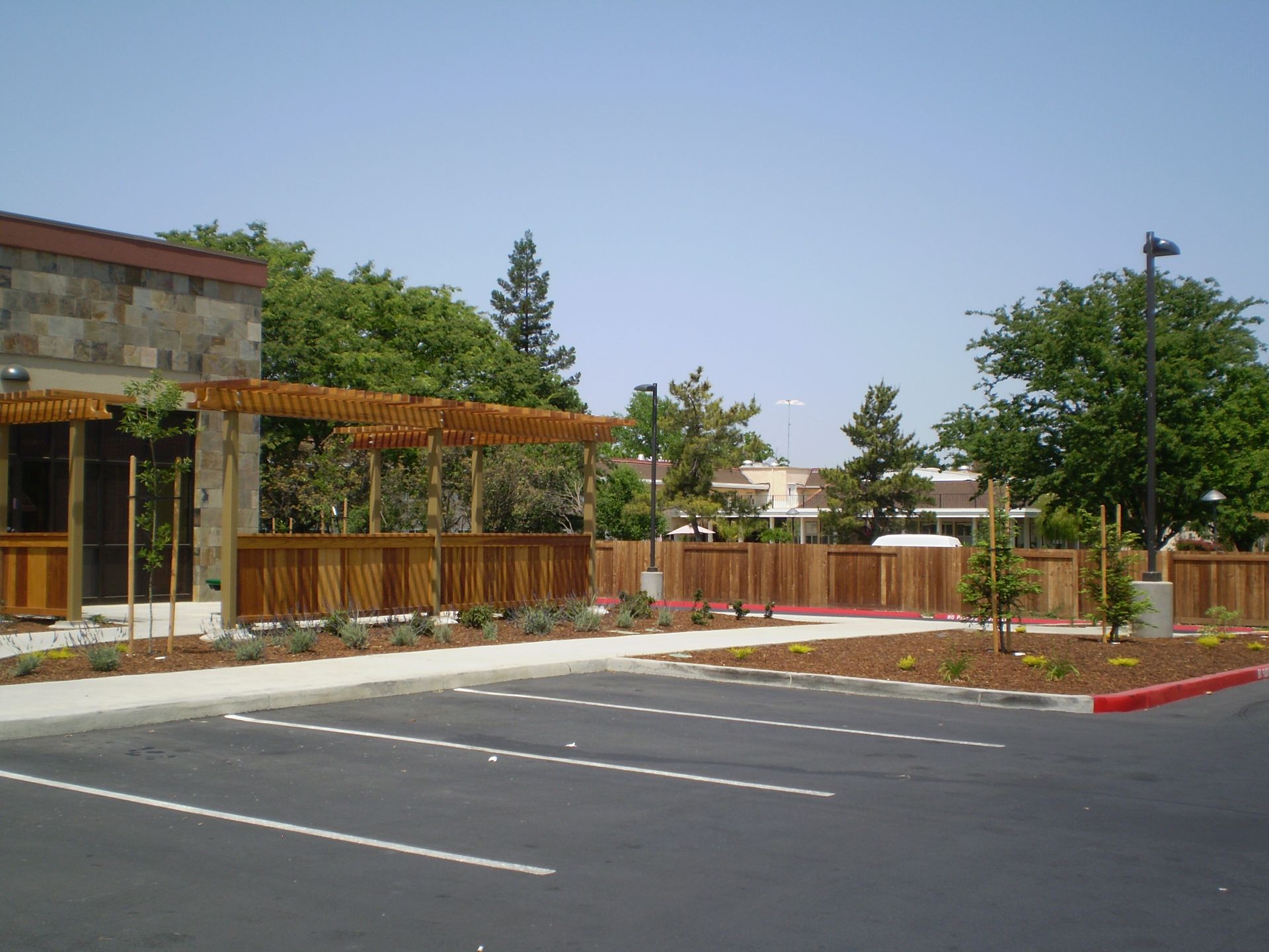 a parking lot in front of a building with a wooden fence