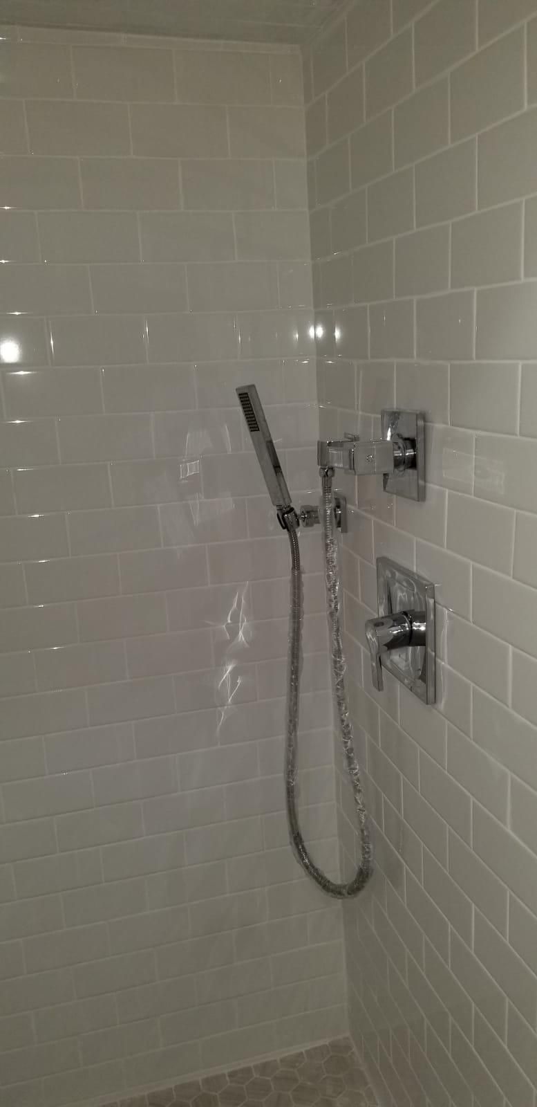 Accessible tiled shower with hand-held showerhead and grab bars