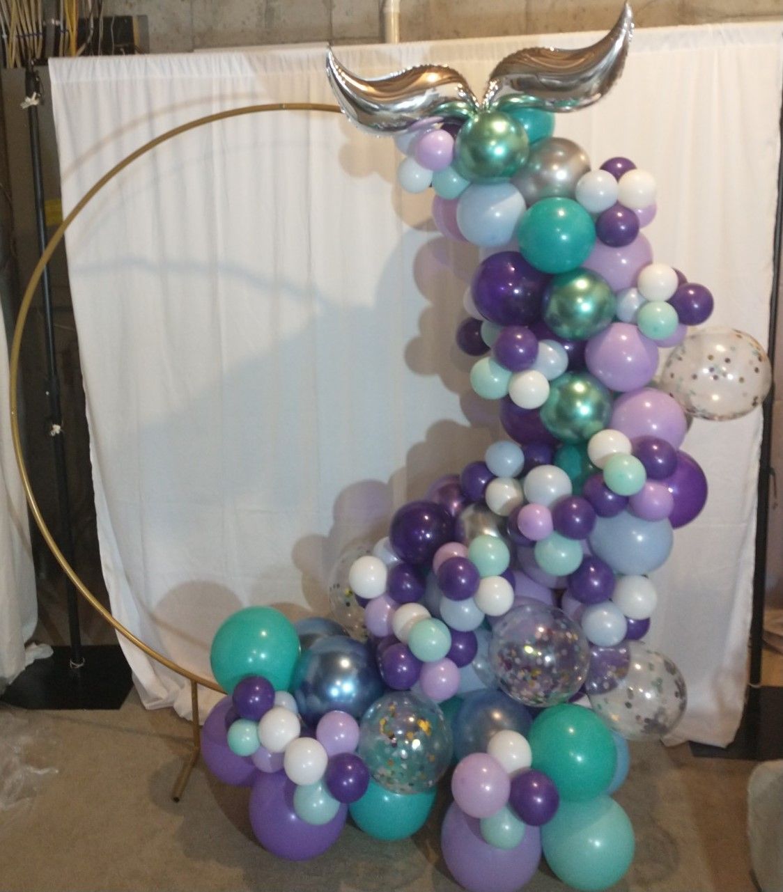 A bunch of balloons with a mermaid tail on top