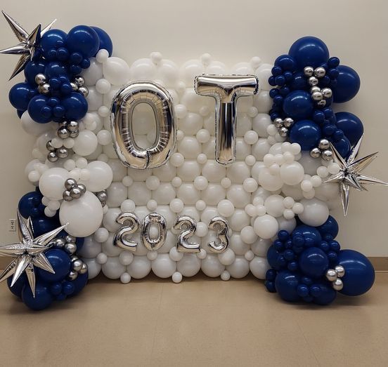 A wall of blue and white balloons with letters ot and 2023