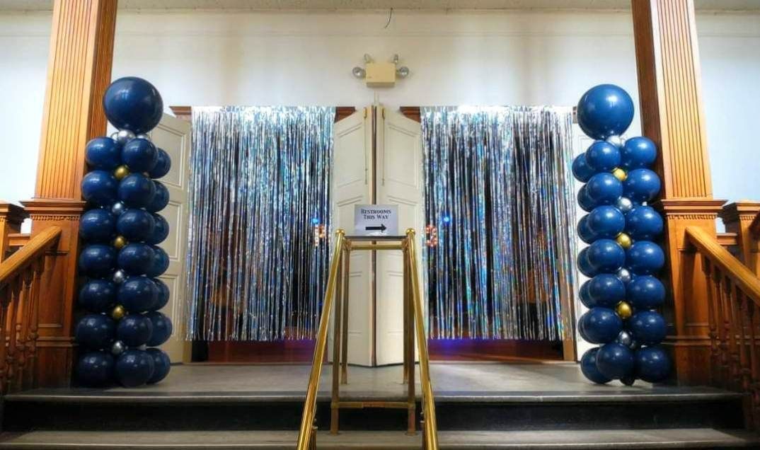 Two columns of blue balloons are sitting in front of a door.