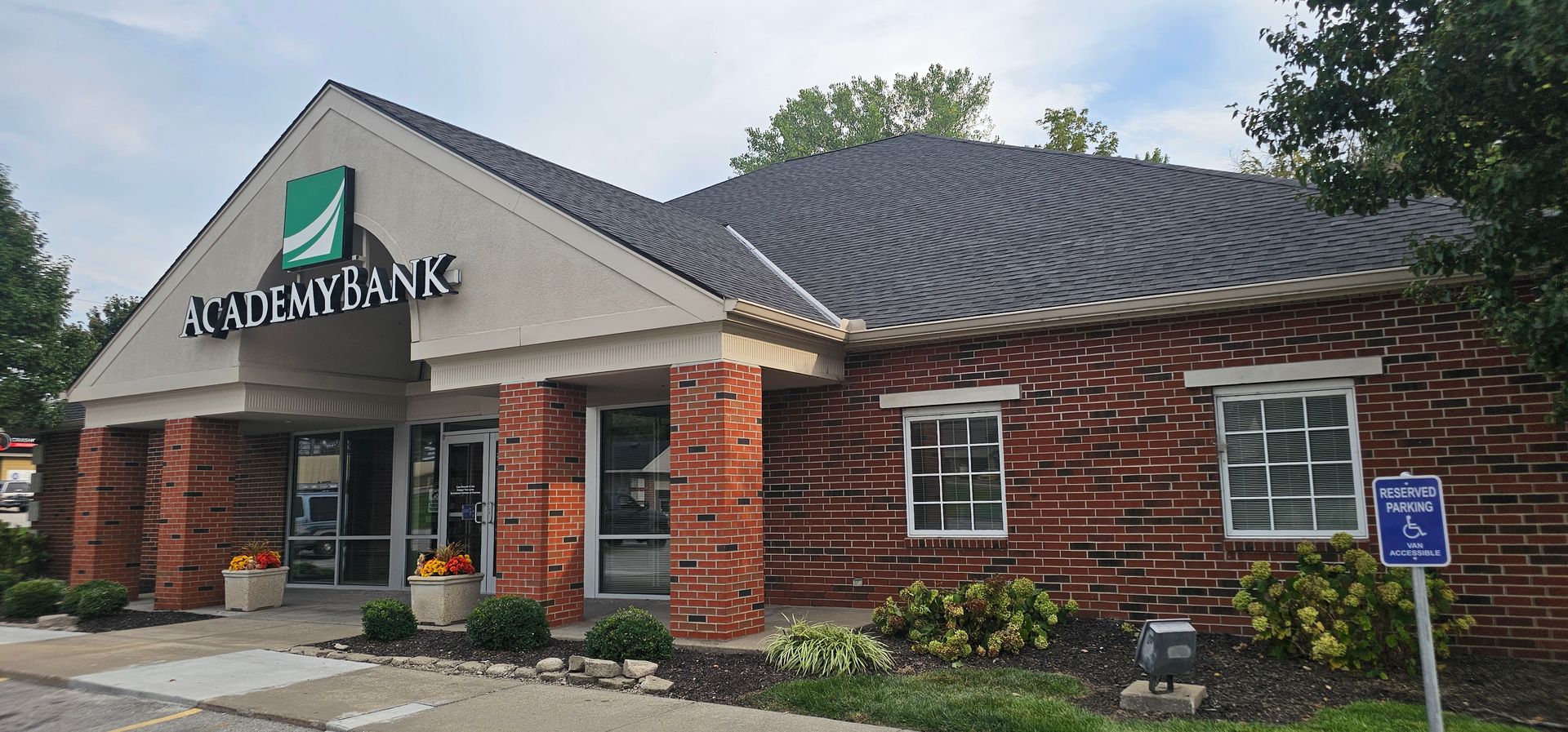 Stonebank bank building with brick facade, black roof, and landscaped front entrance.