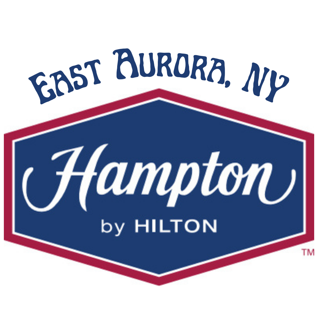 Hampton by Hilton hotel logo in East Aurora, NY. Blue and white text on a navy and red hexagon.
