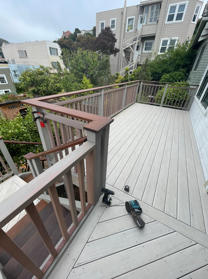 A large deck with a railing and a view of a city.