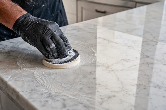 Technician repairing an etch mark on a white marble countertop in a Los Angeles home