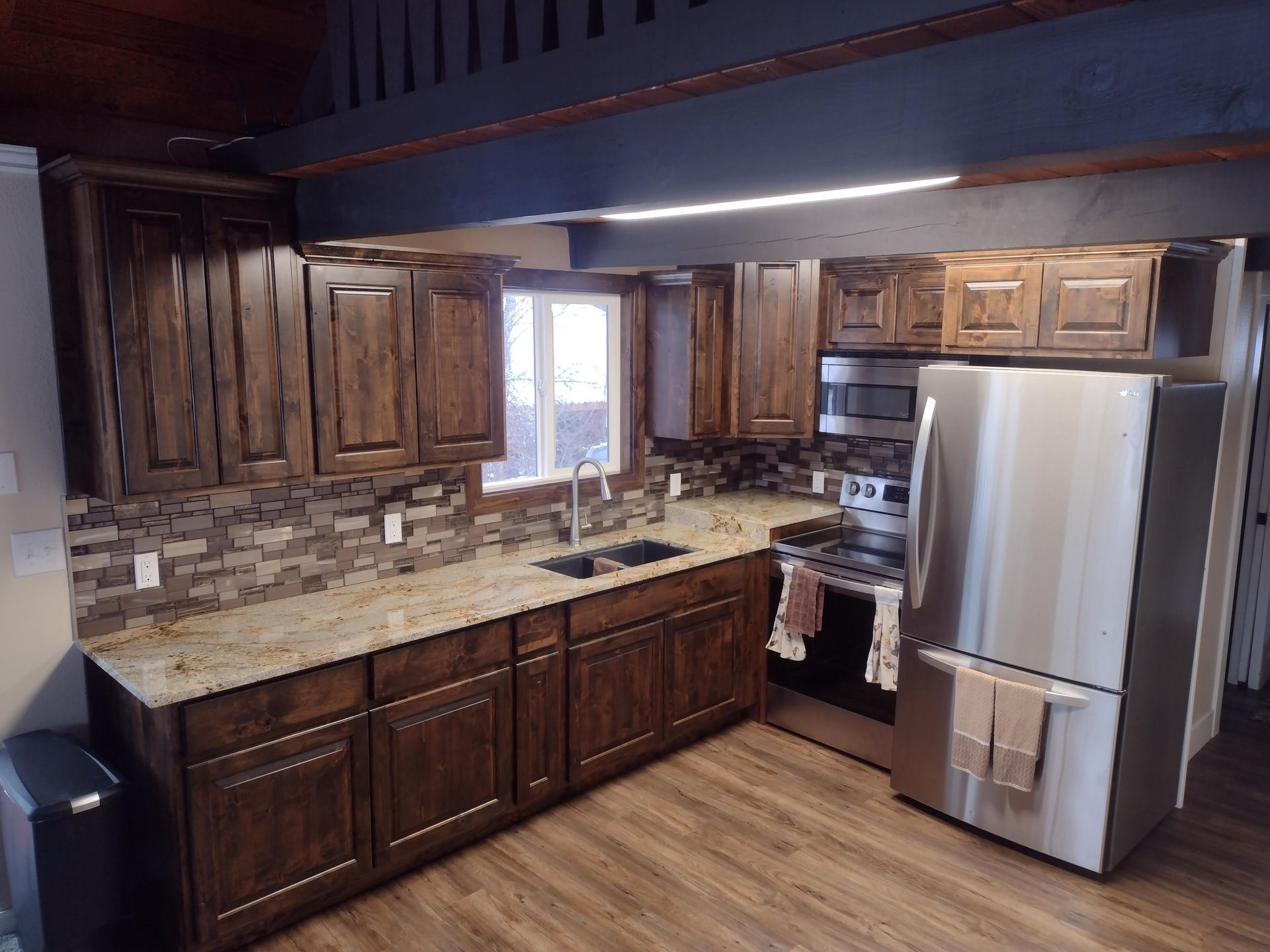 A kitchen with stainless steel appliances and wooden cabinets