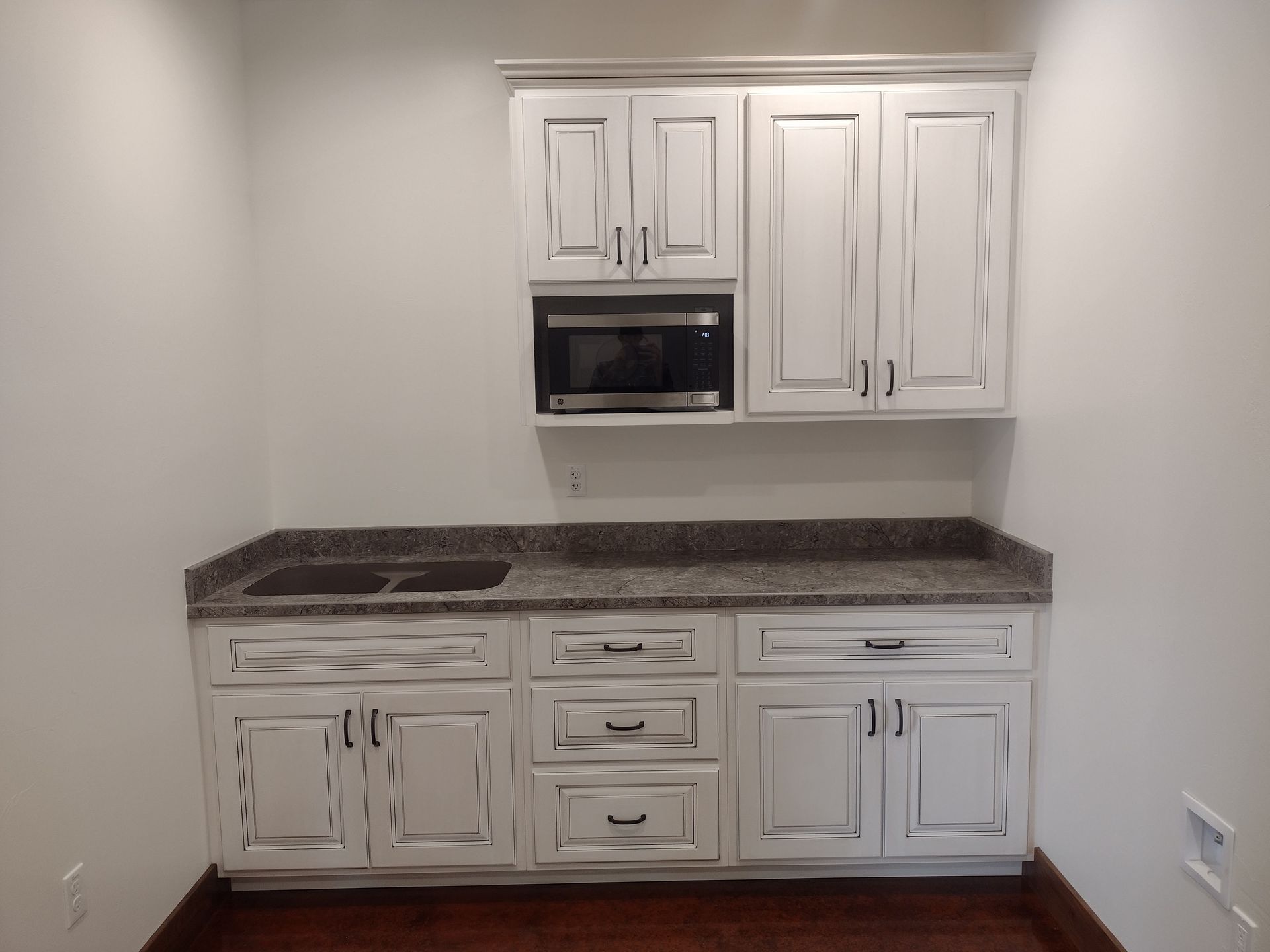 A kitchen with white cabinets and granite counter tops