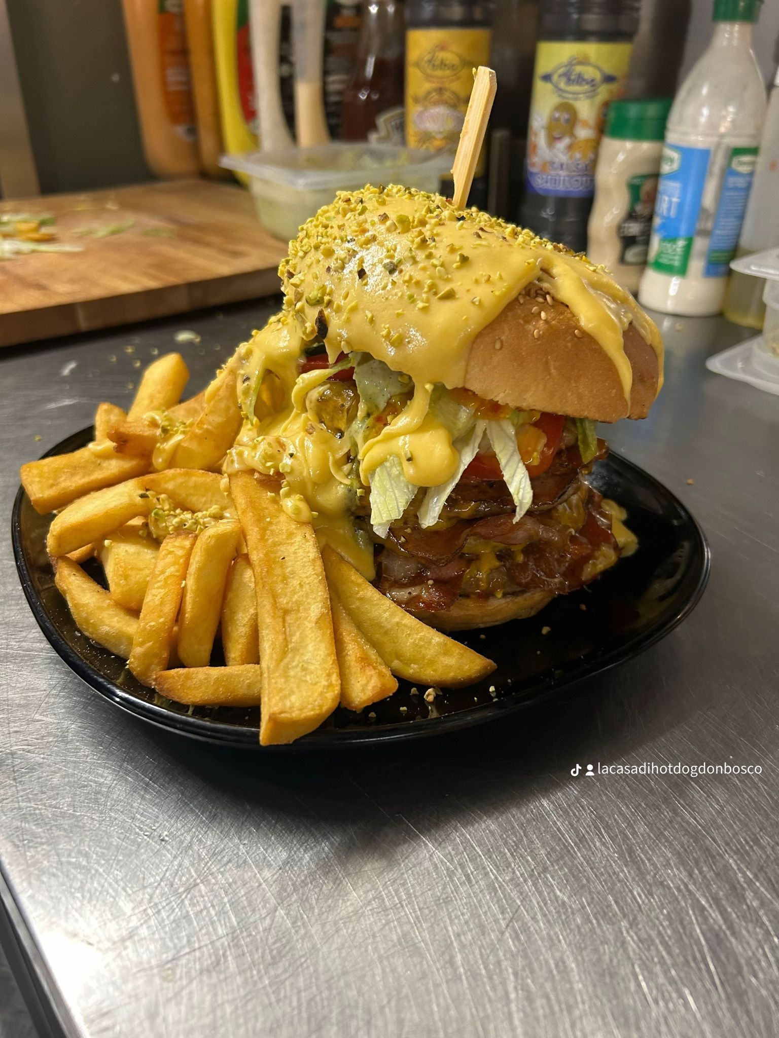 Assortimento di fast food: hot dog, patatine fritte, anelli di cipolla, alette di pollo, birra, senape e jalapeños.