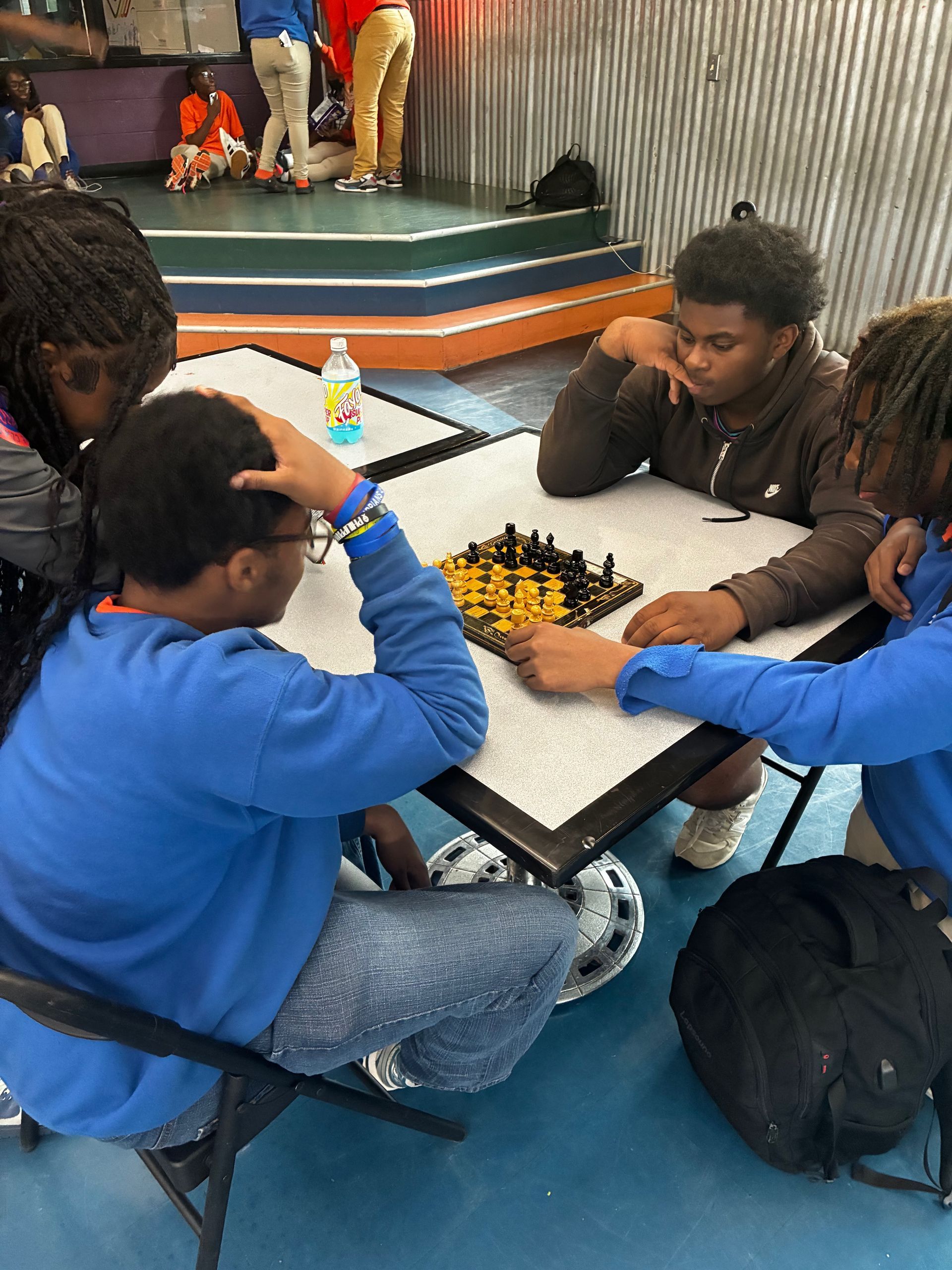 People gathered around a table playing a board game in a bright indoor room.