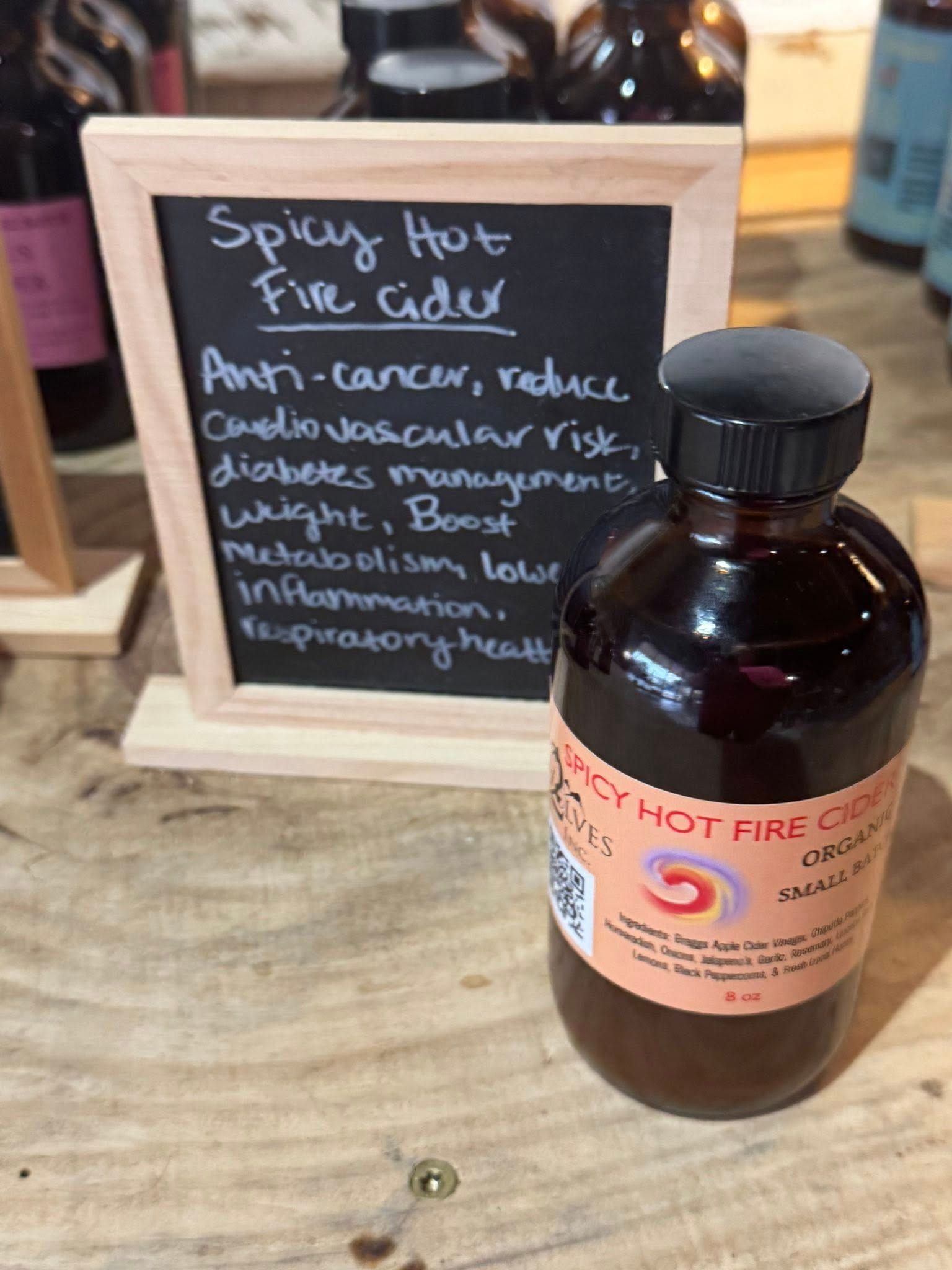 Spicy hot fire cider sign beside a brown bottle on a counter