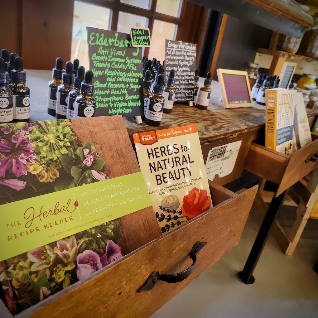 Wooden display of natural beauty products with hand-lettered signs and colorful brochures in a shop.