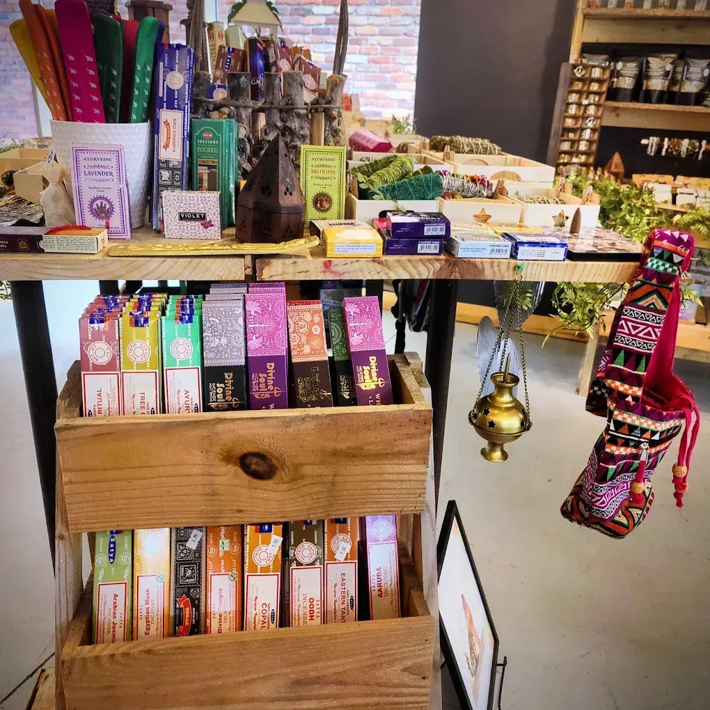 Wooden display of colorful boxed items and hanging ornaments in a small shop booth