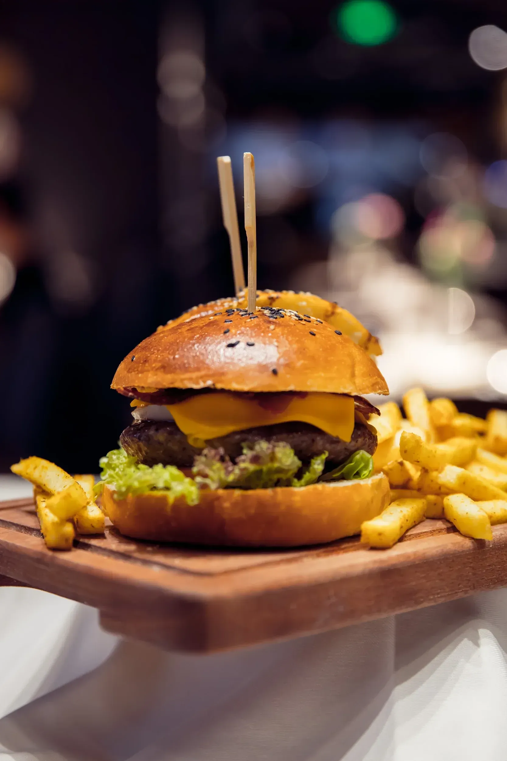 Hamburger with fries on a wooden board.