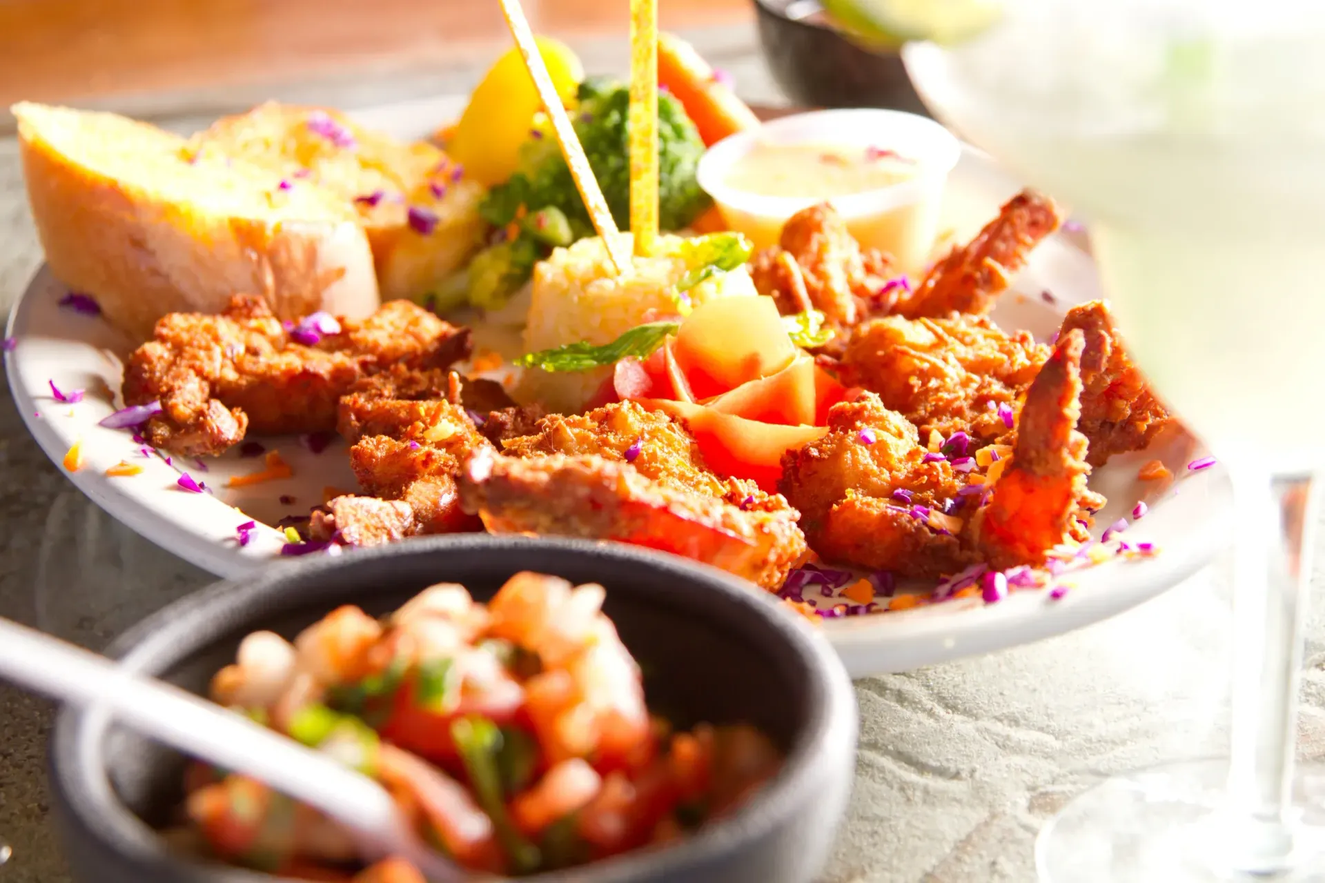 Plate of fried shrimp and sides, a bowl of salsa, and a drink.