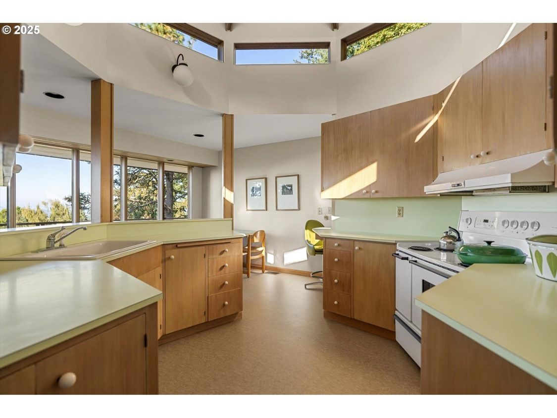 Mid-century modern kitchen with wood cabinets, pale yellow countertops, and a white stove.