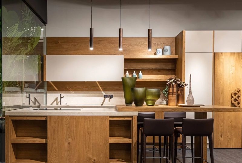 Modern kitchen with wood cabinetry, white accents, and three pendant lights.