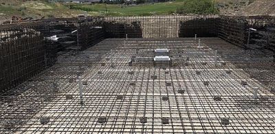A large swimming pool is being built with a lot of wire mesh.