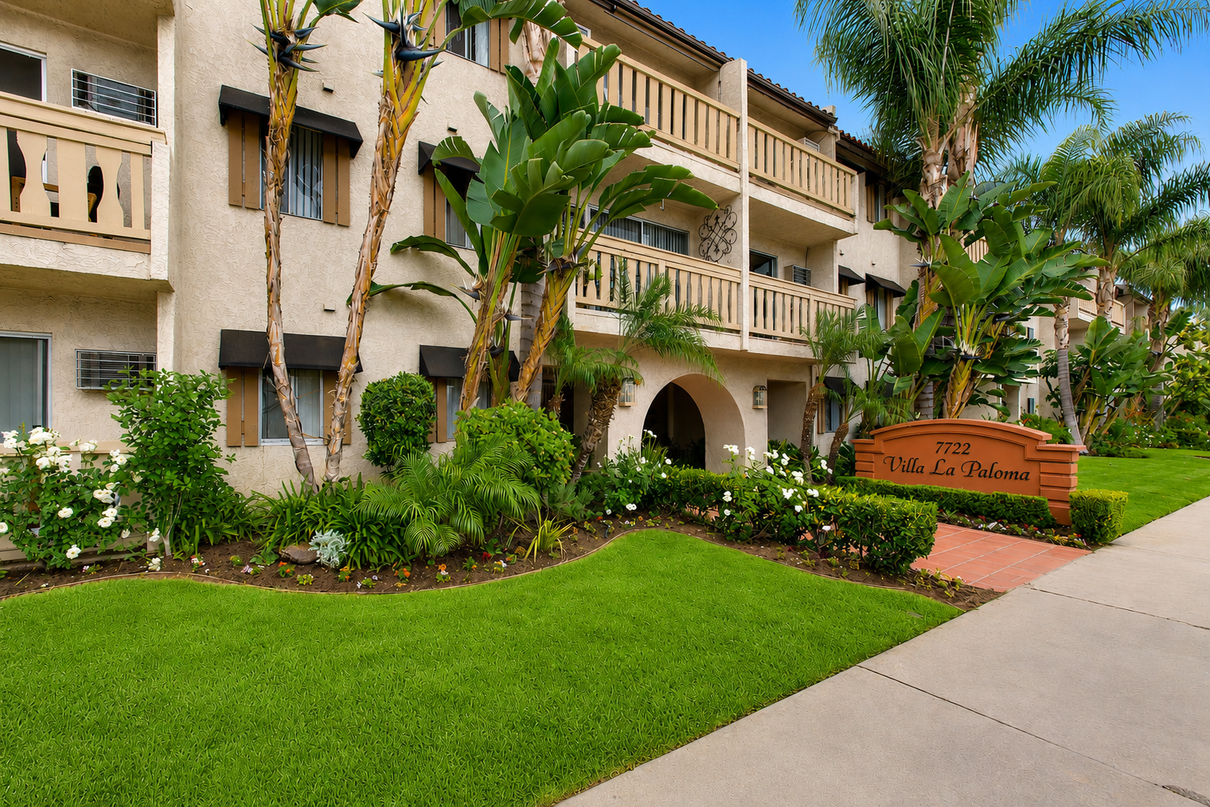 Sunlit apartment buildings with stairs, balconies, and desert landscaping at sunset