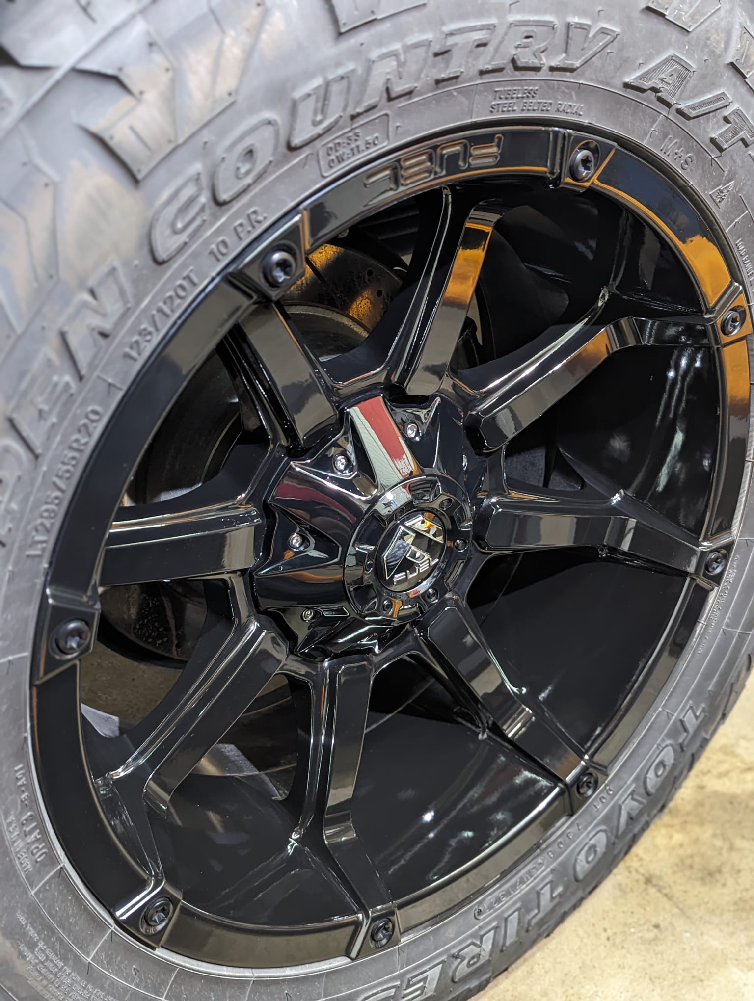 Auto Detailing - A close up of a black tire on a black rim.