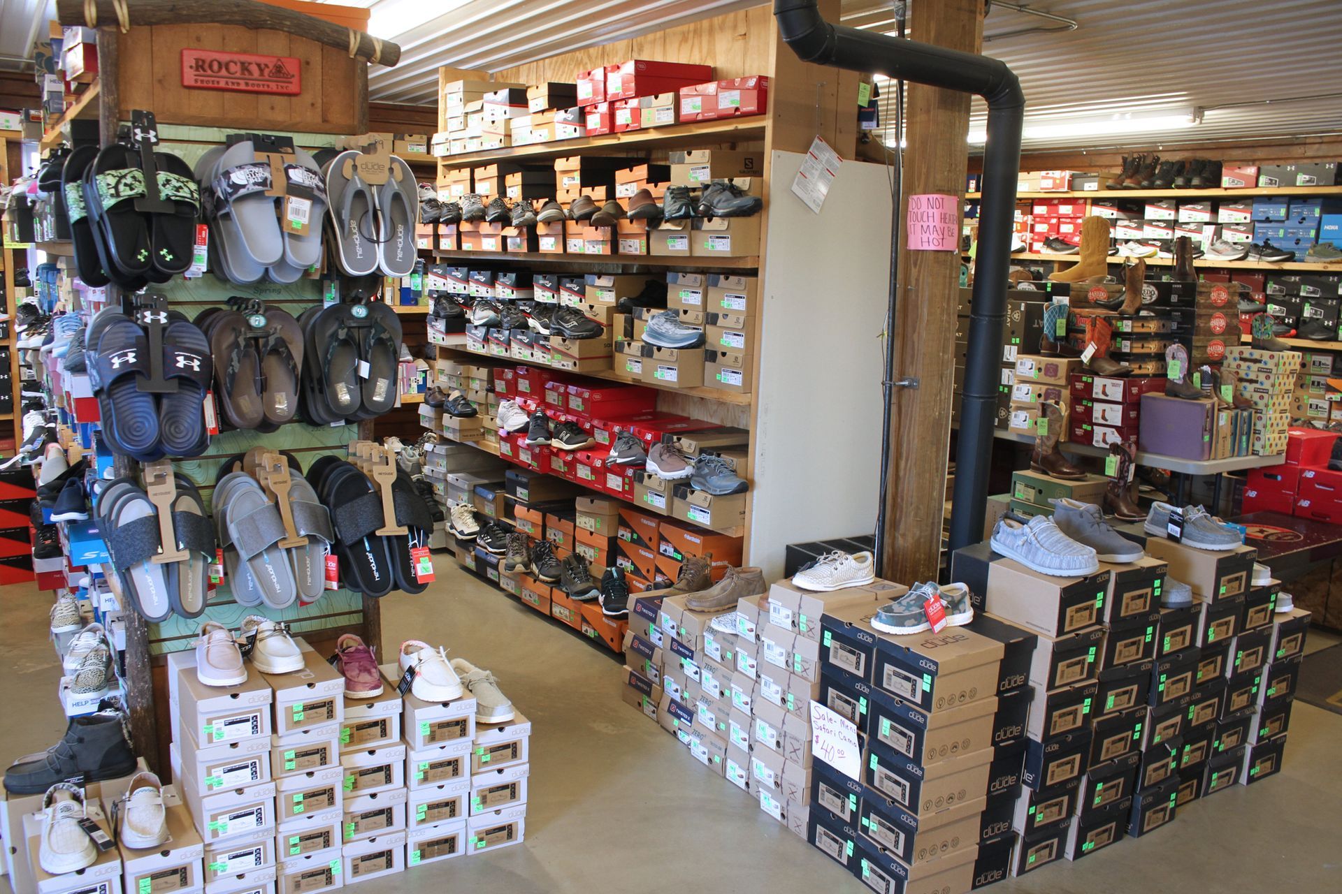 Shoe store interior with shelves and displays of various shoes and boxes.