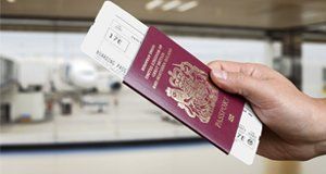 Hand holding a passport and boarding card