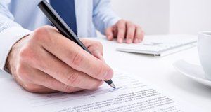 Someone signing a document