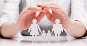 Hands above a white model of parents and two children