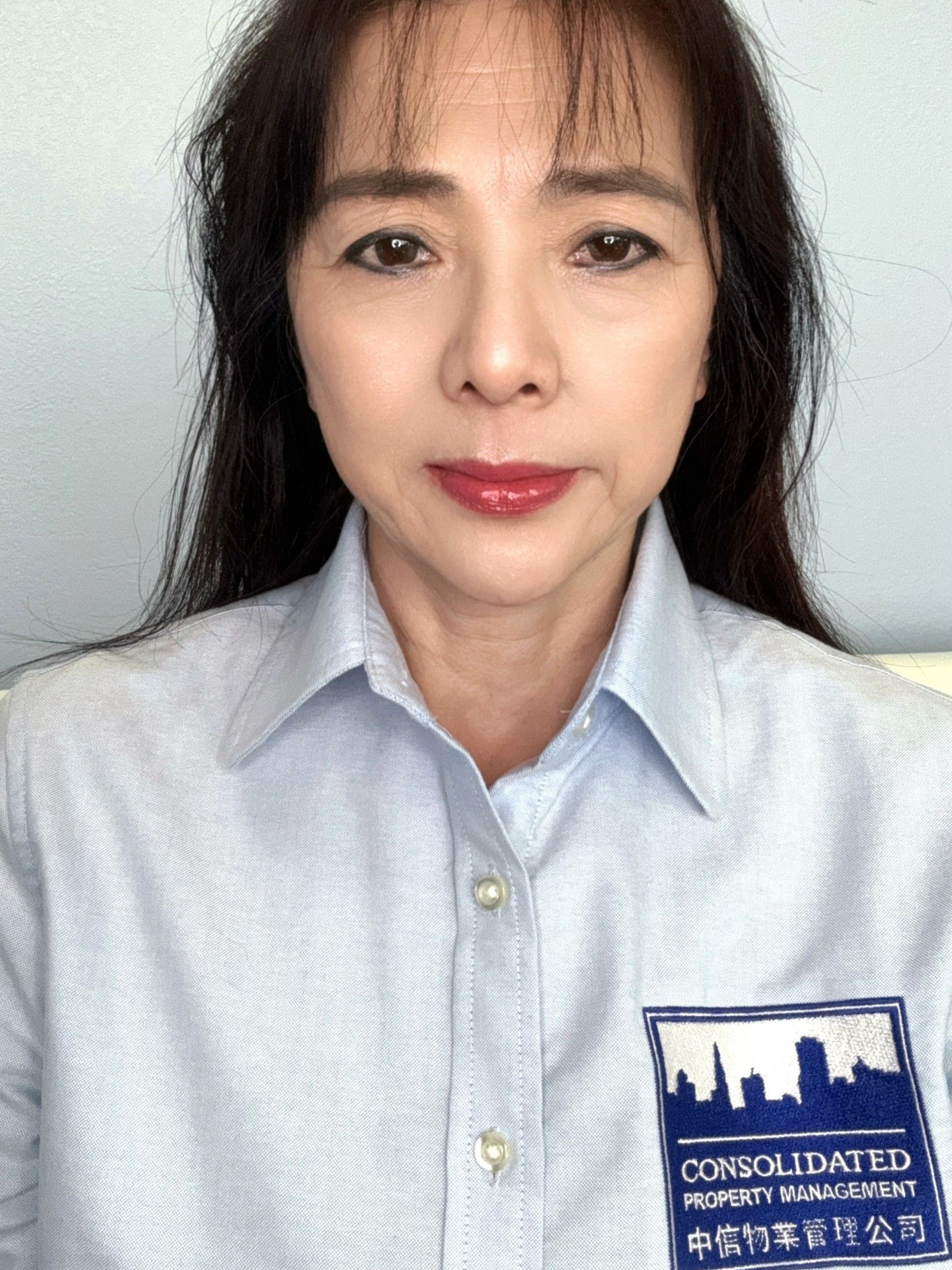 A close up of a woman 's face with long hair and a blue shirt.