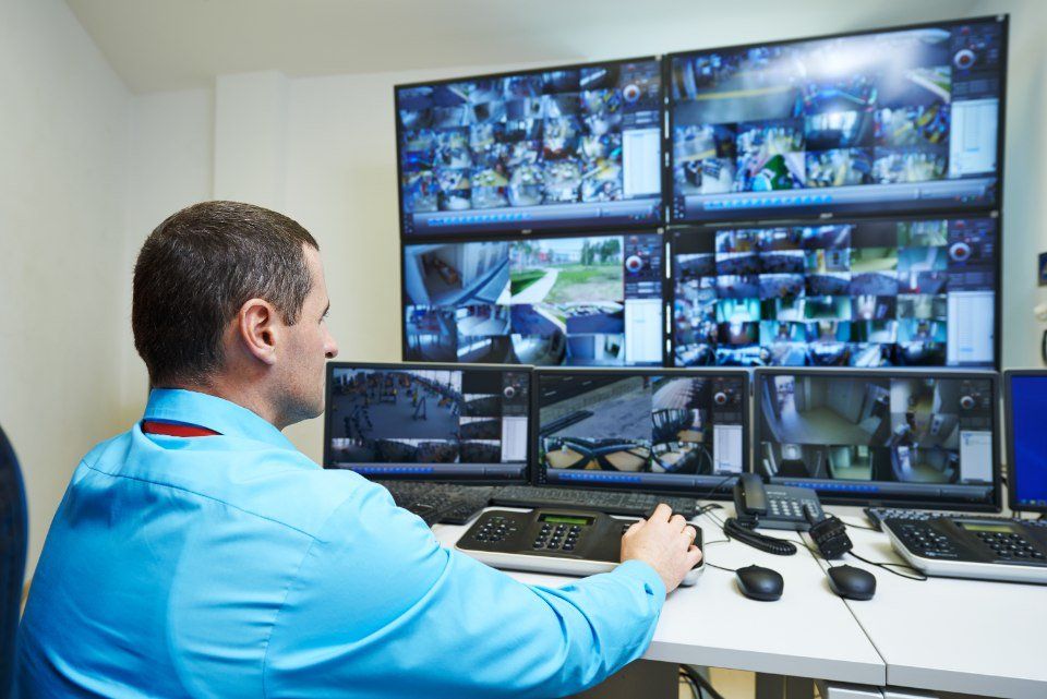 A person looking at many monitors