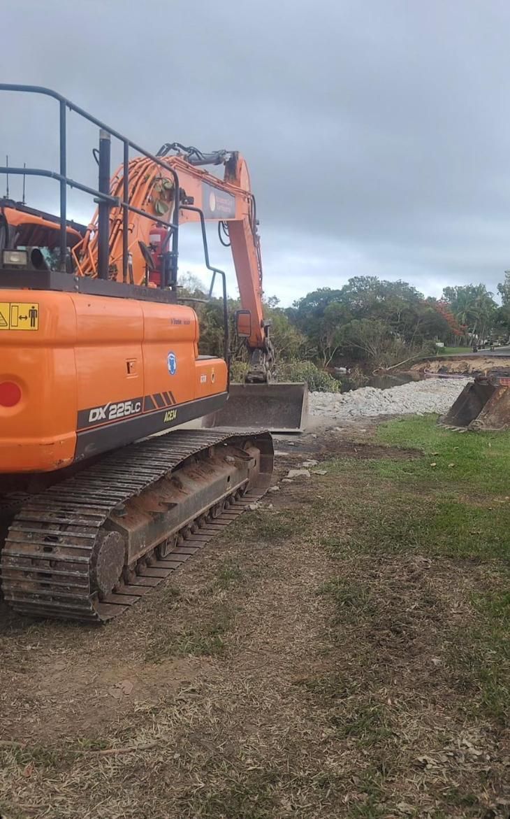 A Large Orange Excavator is Sitting on Top of a Dirt Field — Advanced Civil Earthworks In Koah, QLD
